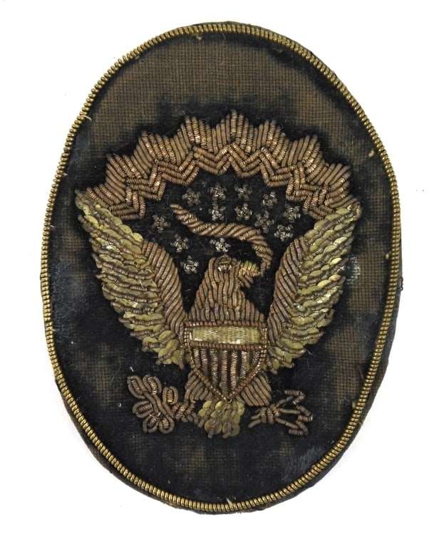 Civil War Officer's Hardee hat Insignia: Black velvet backing with a gold metallic wire around the outside of the insignia, an embroidered eagle, with a brass wire loop on the back (one missing) to attach to the side of an 1858-pattern hat.