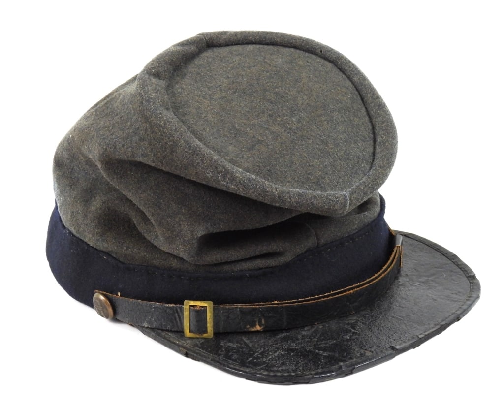 Confederate Forage Cap: Cadet gray body and crown, dark blue band, cuff-size Georgia buttons, Japanned leather chinstrap with a small brass buckle, Japanned leather visor with a cloth bound edge, brown Morocco sweatband