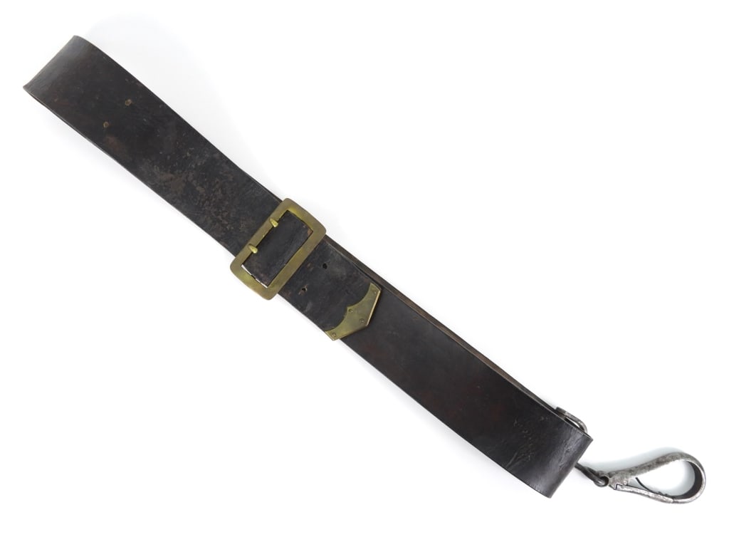 Civil War-era Cavalry Carbine Sling: Black leather cavalry carbine sling with a brass buckle, riveted brass tip, with an unmarked carbine swivel. United States C. 1860s Overall wd. 2 1/2"