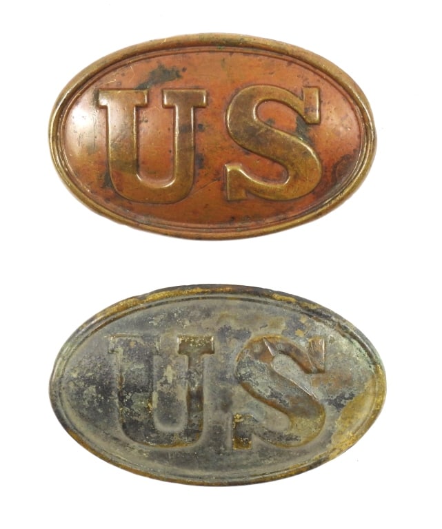 Two Civil war-era Cartridge Box Plates: Two led-filled brass plates marked "US", with iron wire attachment loops on the back. United States C. 1860s Overall lg. 3 3/8"