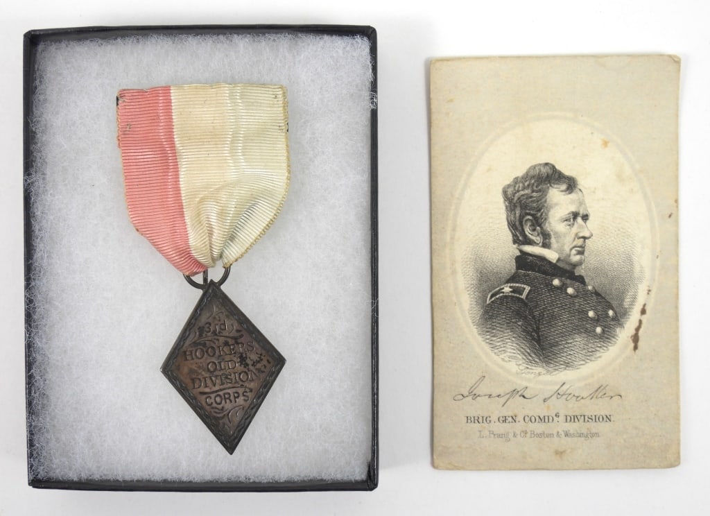 3rd Corps "Hookers Old Division" Badge: Red, white, and blue (faded) silk ribbon with a brass back at the top and pin for attaching, with a silver 3rd Corps insignia marked "3rd/HOOKERS/OLD/DIVISION/CORPS". United States Overall ht. 3 3/8"
