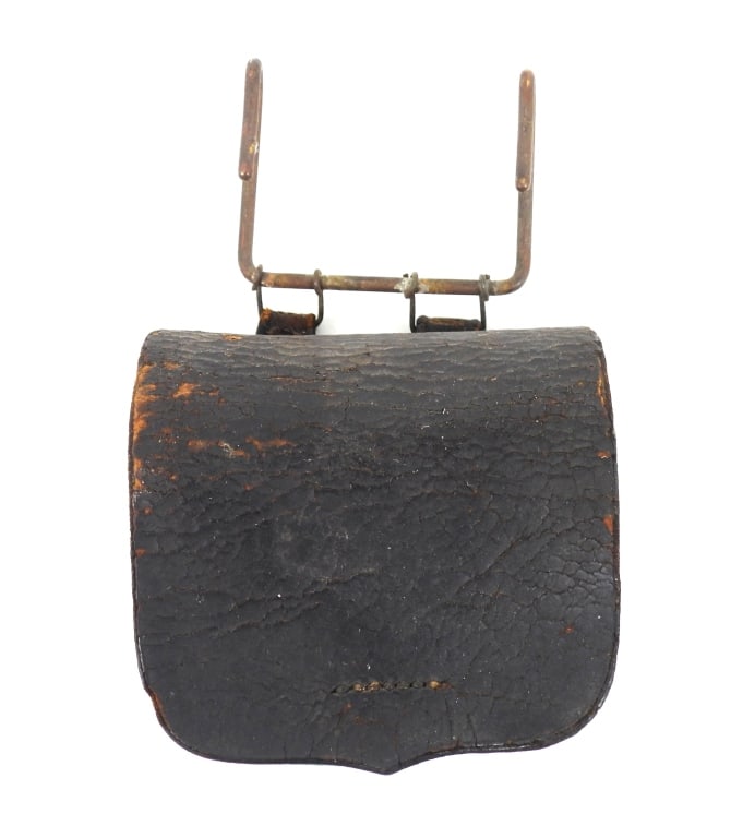 Civil War-era Cap Box with Brass Suspension Hooks: Black leather cap box with no visible markings, brass finial, with two sewn belt loops on the back fitted with iron wires to a brass U-shaped belt hook. United States