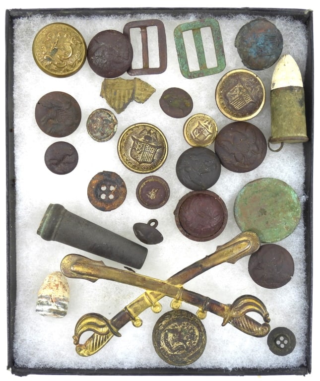 Group of Civil War Buttons and Artifacts: Two forage cap chinstrap buckles; a brass cavalry cap insignia; a non-dug coat-size Rhode Island button marked "EVANS & CO" on the back; two shell casings; and a group of dug state and general service
