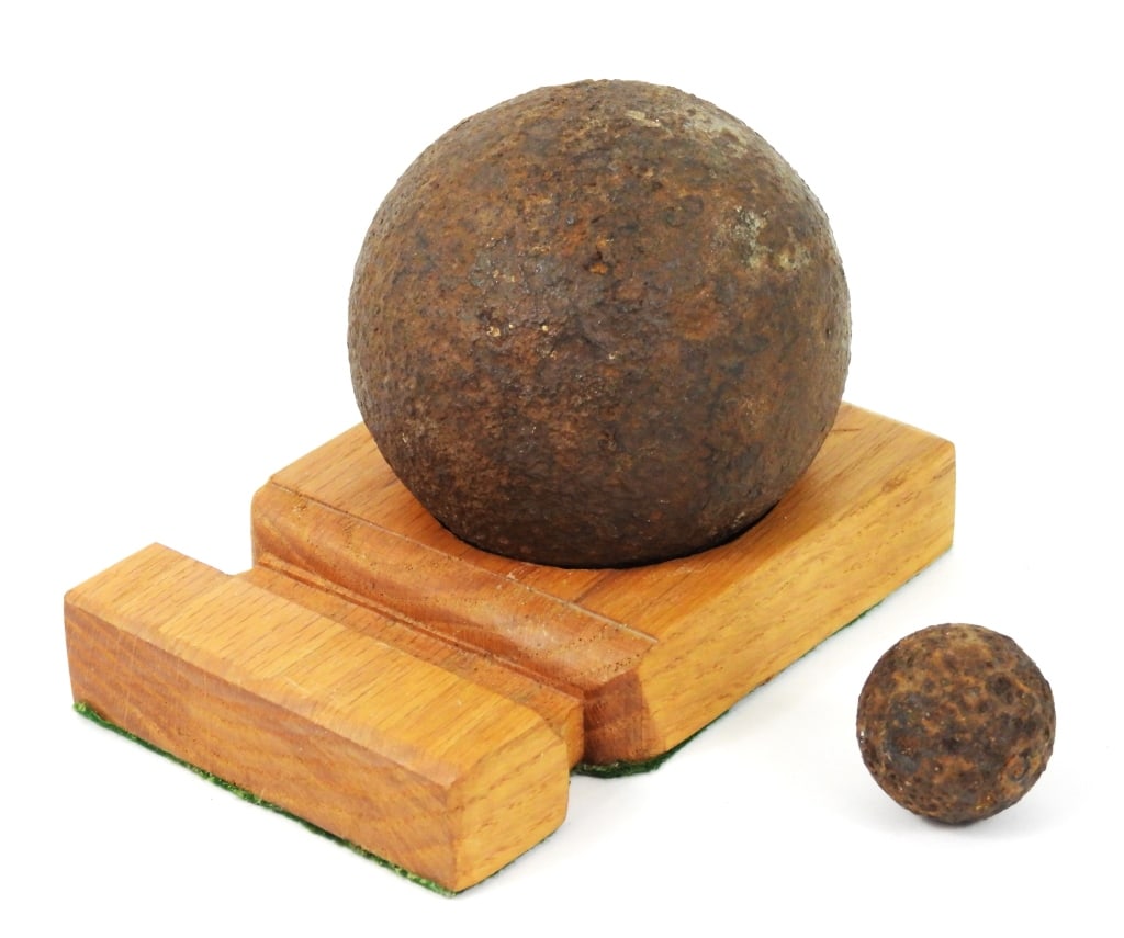 Six-Pound Solid and Grape Shot: A dug six-pound solid shot; and a dug grape shot, with an oak base. United States