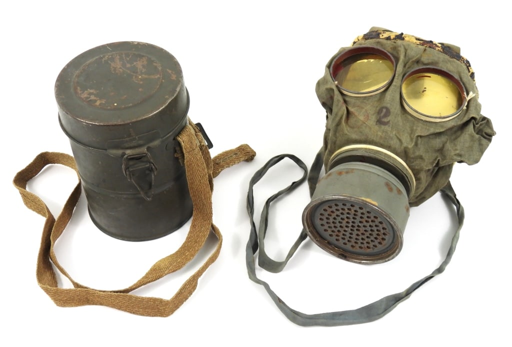 WWI German Gas Mask and Can: Green-painted steel gas mask can with ersatz cloth strap, with intact gas mask, straps, and a 1918-dated filter. Germany C. 1918