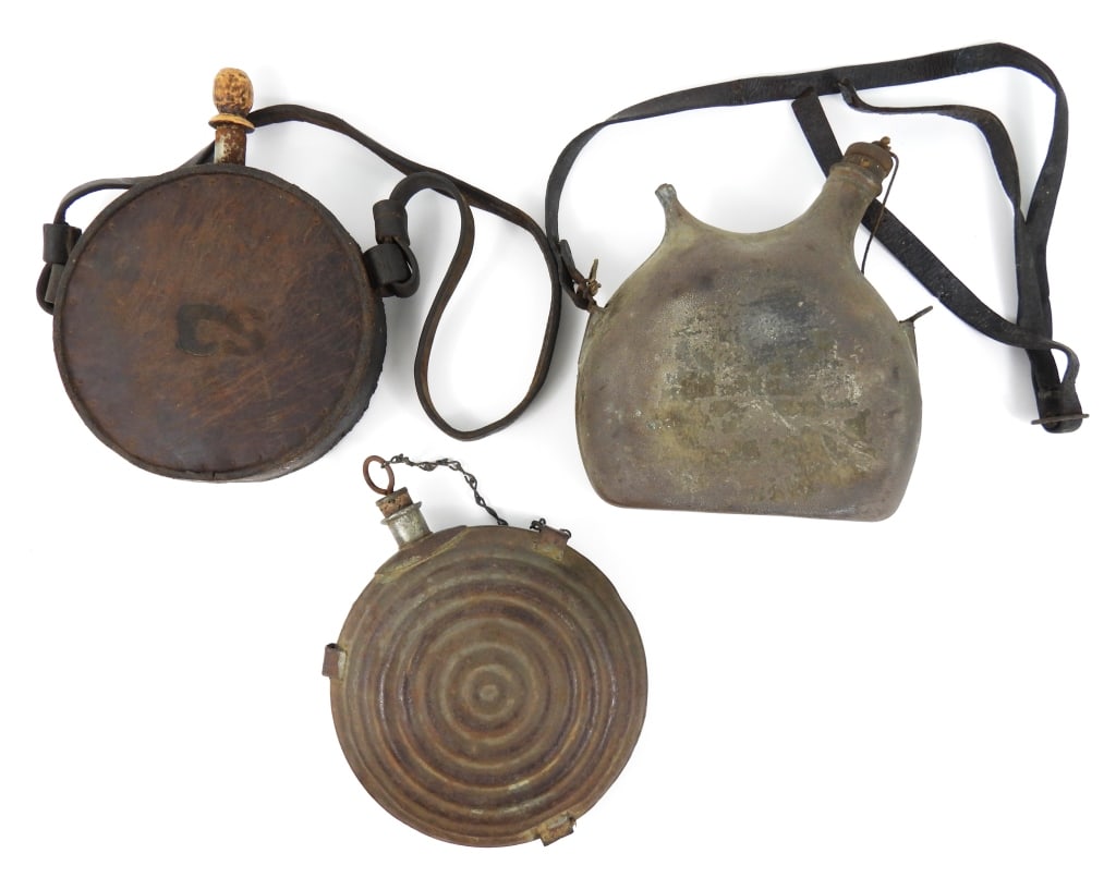 Three Military Canteens: A WWI French canteen with a broken leather strap; a Civil War "bullseye" canteen with a stopper and pewter spout with makers mark; and a fantasy leather-covered Confederate canteen. United States/Fran