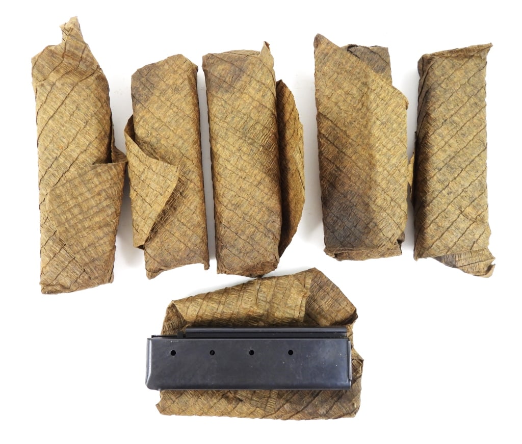Six Patent Date Thompson SMG Shot Magazines: Six patent date Thompson SMG magazines in a paper wrapping marked "PATENTED-AUG. 24, 1920/FOR 18 SHOT CARTRIDGES/AUG 24, 1920.-JAN.- 11- 1921". United States Overall lg. 6 1/4" Disclaimer and lot