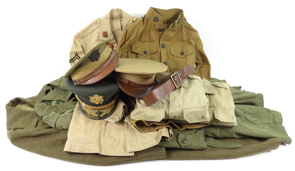 Group of Military Uniforms: A tan/khaki cotton WWI tunic with engineer collar insignia; a WWII-era khaki cotton tunic with artillery inginia, DI's, and a leather belt; two khaki cotton shirts; a WWII overcoat; a Korean War-era