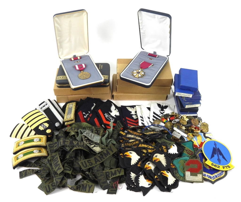 Large Group of Military Insignia: Group of 101st Airborne patches, U.S. Army insignia, navy patches, boxed WWII campaign medals, a cased Legion of Merit, cased Meritorious Service medals, cased Army Commendation medal, and two cased A