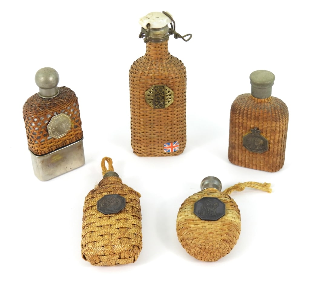 Grouping Of English Flasks With Woven Wraps: Five antique English and Continental glass pocket flasks, each having applied devices. They are wrapped with either wicker, rush, or rattan material. Tallest is 8" high and shortest is 5.25" high.