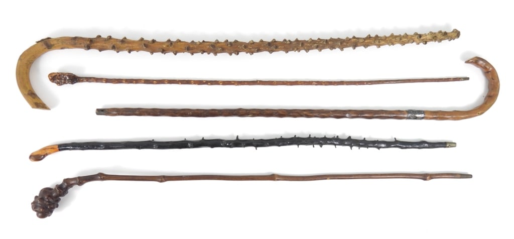 Grouping Of Antique Canes: Various form wood canes, one having a "Solid Silver" 1-1/2" wide band wrapped floral design near handle that is missing the ground cap. Longest is 37".
