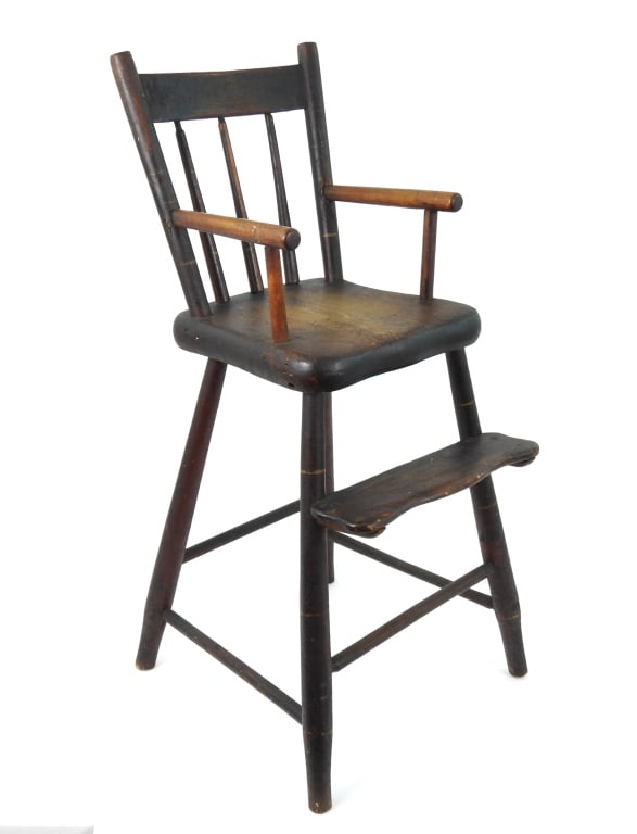 Windsor Style Childs High Chair Signed: Antique with old black surface over red paint with splay legs and an affixed foot rest. There is a makers name to underside of seat in black paint "N H / Watertown". The chair tilts slightly to the