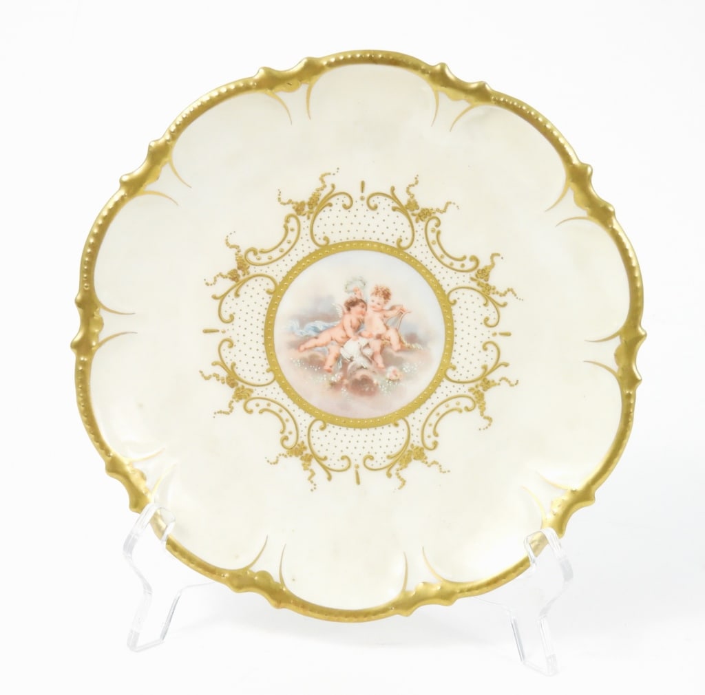 Victorian Era Limoges Putti Scene Plate: Porcelain Coronet France cabinet plate with a Rococo style hand painted cherubs scene and a scalloped edge gilt border. Measures 8-1/2" diameter.