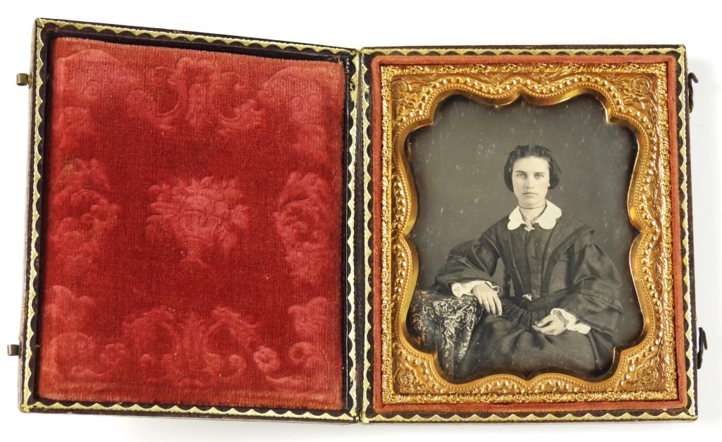 Antique 6th Plate Portrait Photograph of a Woman: A 6th plate portrait in a case of a beautiful seated woman with hand-tinted pink cheeks, wearing an elaborate dress with large sleeves. The wooden case is embossed with gold trim and is in good shape.