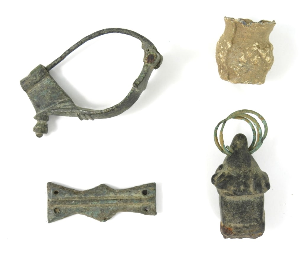 Grouping Of Ancient Roman Era Items: Includes a 2-1/4" long cloak Fibula. A 1-3/4" long fabulous belt stiffener. A small 1" high lead jar, and heavy 1-1/2" long metal pendant.