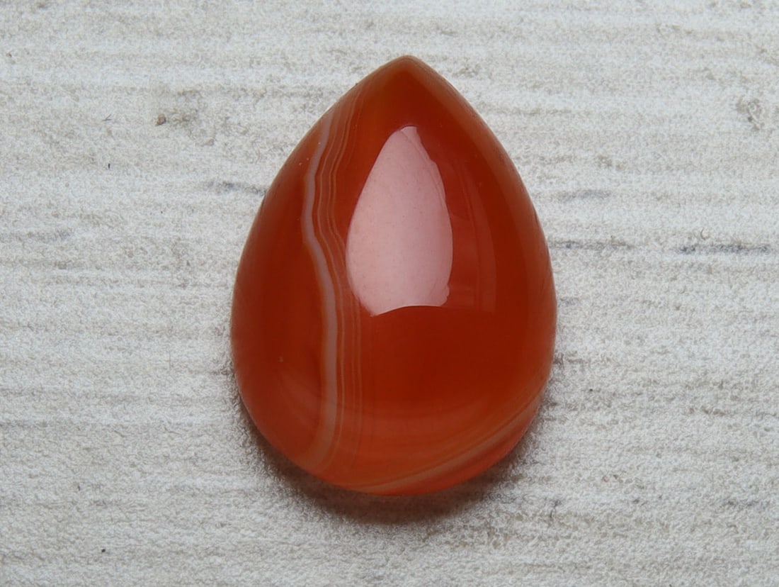 Wonderful 5.09 Cts Natural Carnelian: Gemstone : Natural Carnelian // Weight : 5.09 carat // Shape : Pear Cabochon // Dimensions : 14x10 mm // Color : Orange // Origin : India // Treatment : Heated // Transparency : Translucent