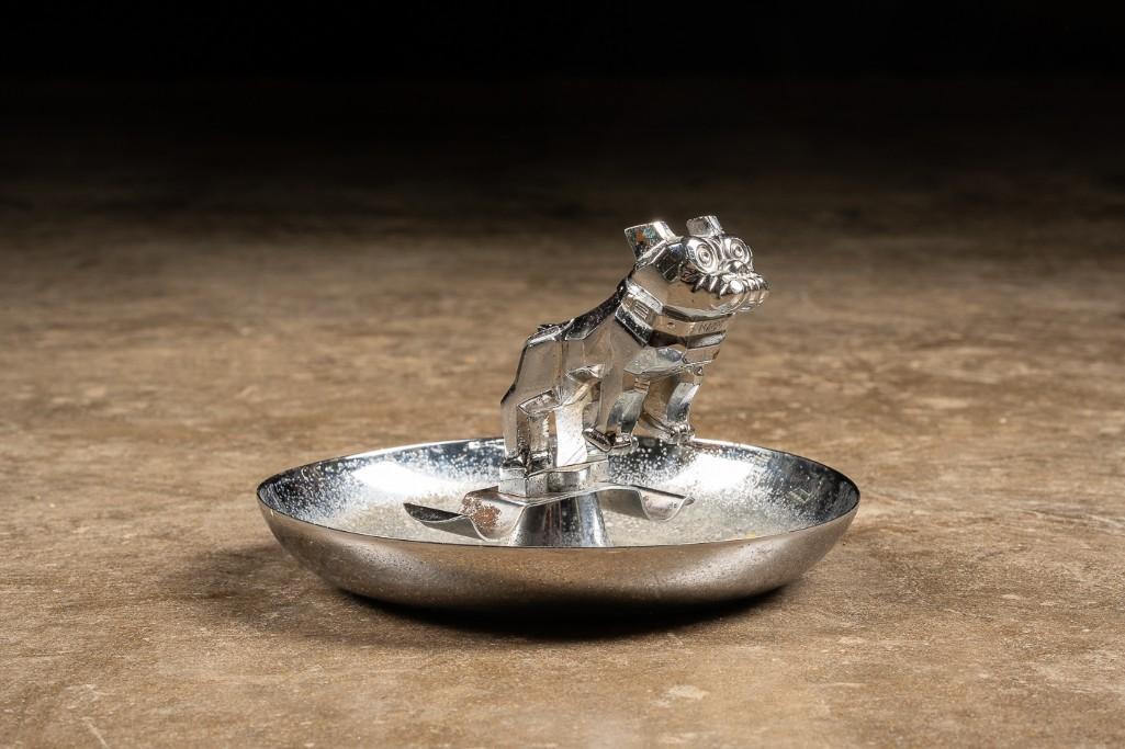 Vintage Die Cast Mack Truck Ashtray: This vintage Mack Truck emblem ashtray likely originated in the 1930s. This piece was manufactured by the Central Die Casting MFG out of Chicago IL. This geometric piece is made of rhodium plated meta