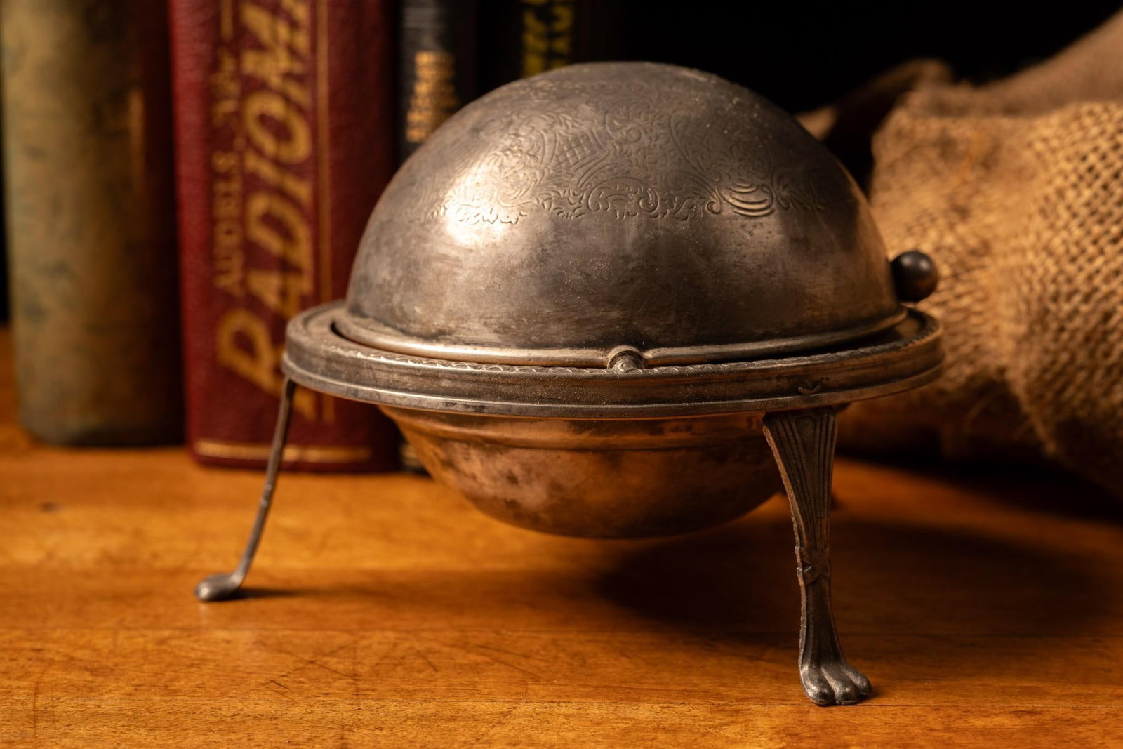 Vintage Roll Top Ashtray: Engraved metal roll top ashtray on claw feet. Exhibits minor tarnish. 5" dia and 5" H