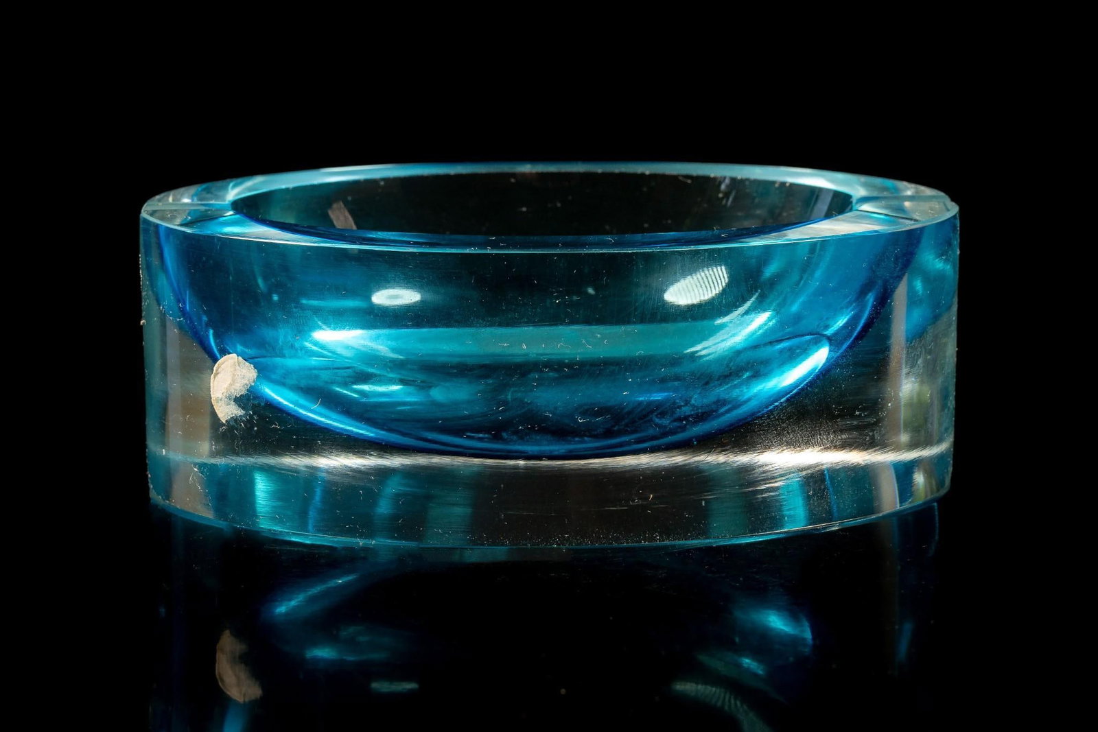 Blue Elliptical Ashtray: Oval-shaped decorative ashtray in a semi-transparent shade of cerulean. Appears to be free from cracks and chips, but exhibits moderate scratches. 6.5" x 5" x 2.5"