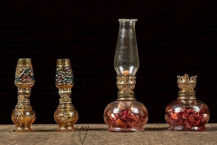 Set of (4) Miniature Oil Lamps: NOTE: For an accurate in-house shipping quote on this lot, please reach out to us at rockauctiongallery@gmail.com. Item SKU: C-13577 This lot includes two taller clear glass oil lamps. The bases of th