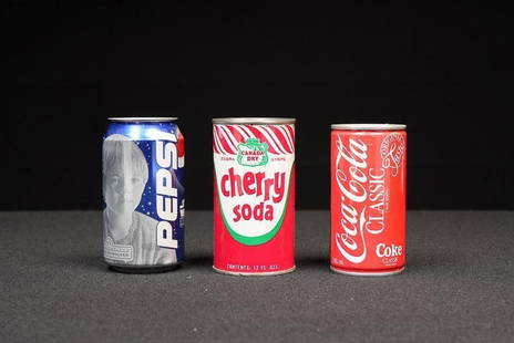 Lot of Three Vintage Soda Cans: NOTE: For an accurate in-house shipping quote on this lot, please reach out to us at rockauctiongallery@gmail.com. Item SKU: C-16079 This lot includes three collectible soda cans spanning different er