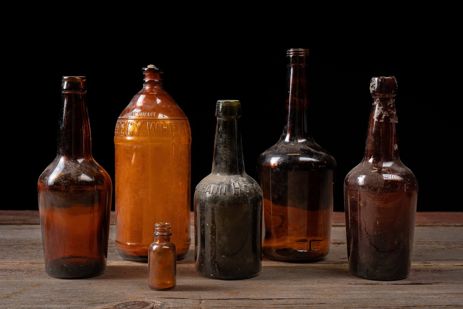 6 Antique Amber Bottle Group- Fleecy White: **NOTE: Any shipping quotes provided on this screen or on your Live Auctioneers invoice are provided by Live Auctioneers. In-house shipping is available on all lots. For in-house shipping quotes, plea