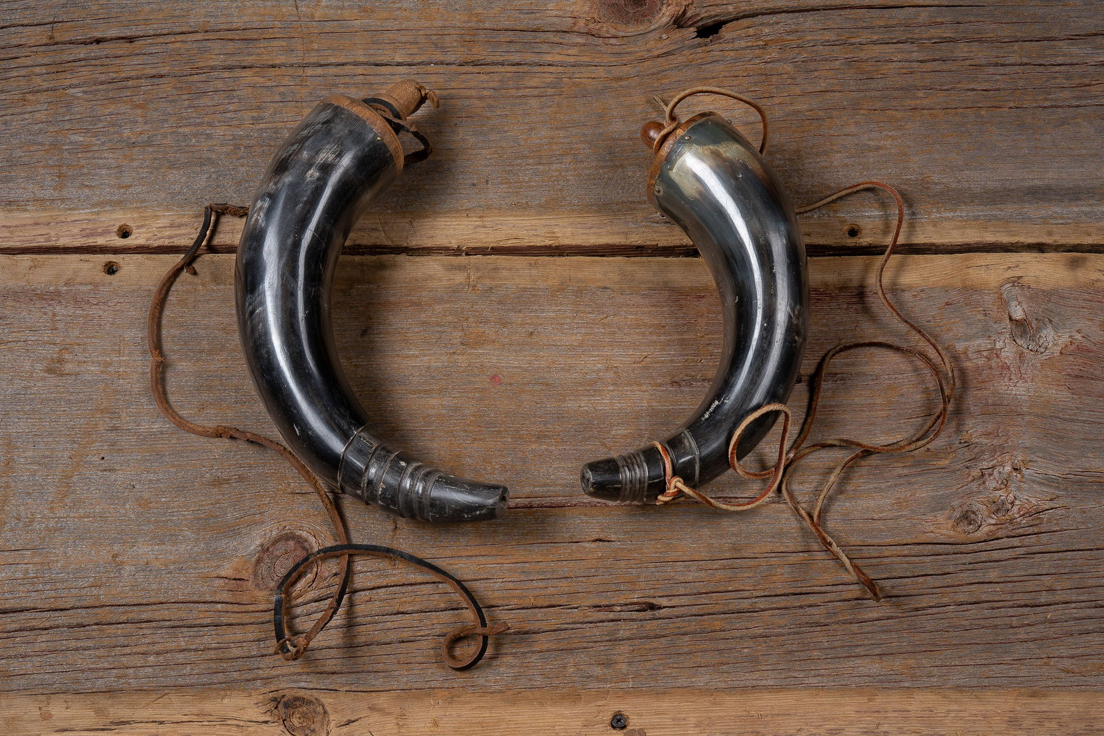 Pair of Black Powder Horns with Leather Straps: **NOTE: Any shipping quotes provided on this screen or on your Live Auctioneers invoice are provided by Live Auctioneers. In-house shipping is available on all lots. For in-house shipping quotes,
