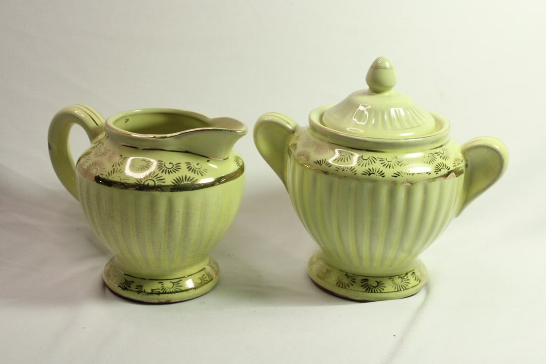 Pair of Redware Creamer and Sugar Container: made in Japan - possibly 1940's - please note: some crazing on the lower portions - the design and gold decoration shows some wear as shown - creamer: 3 1/2" tall - sugar container: 3 6/8" tall withou