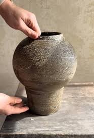 Handcrafted Ceramic Vase: A tall, handcrafted ceramic vase with a matte finish, ideal for dried flowers or decorative arrangements.