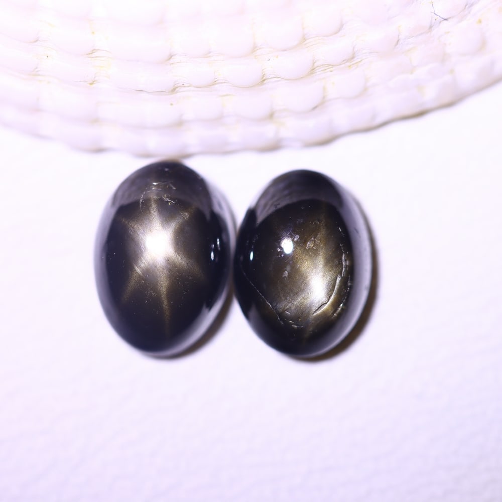 2.75cts 6 Rays Black Star Sapphire Pair , 518E: Ksmith Heritage Auctioneers Subject: Natural 6 Rays Star Sapphire Origin: Myanmar Carat Weight: 2.75cts Dimension: 6.9x5x3.9 mm Treatment: Diffusion Type: Cabochon, Polish