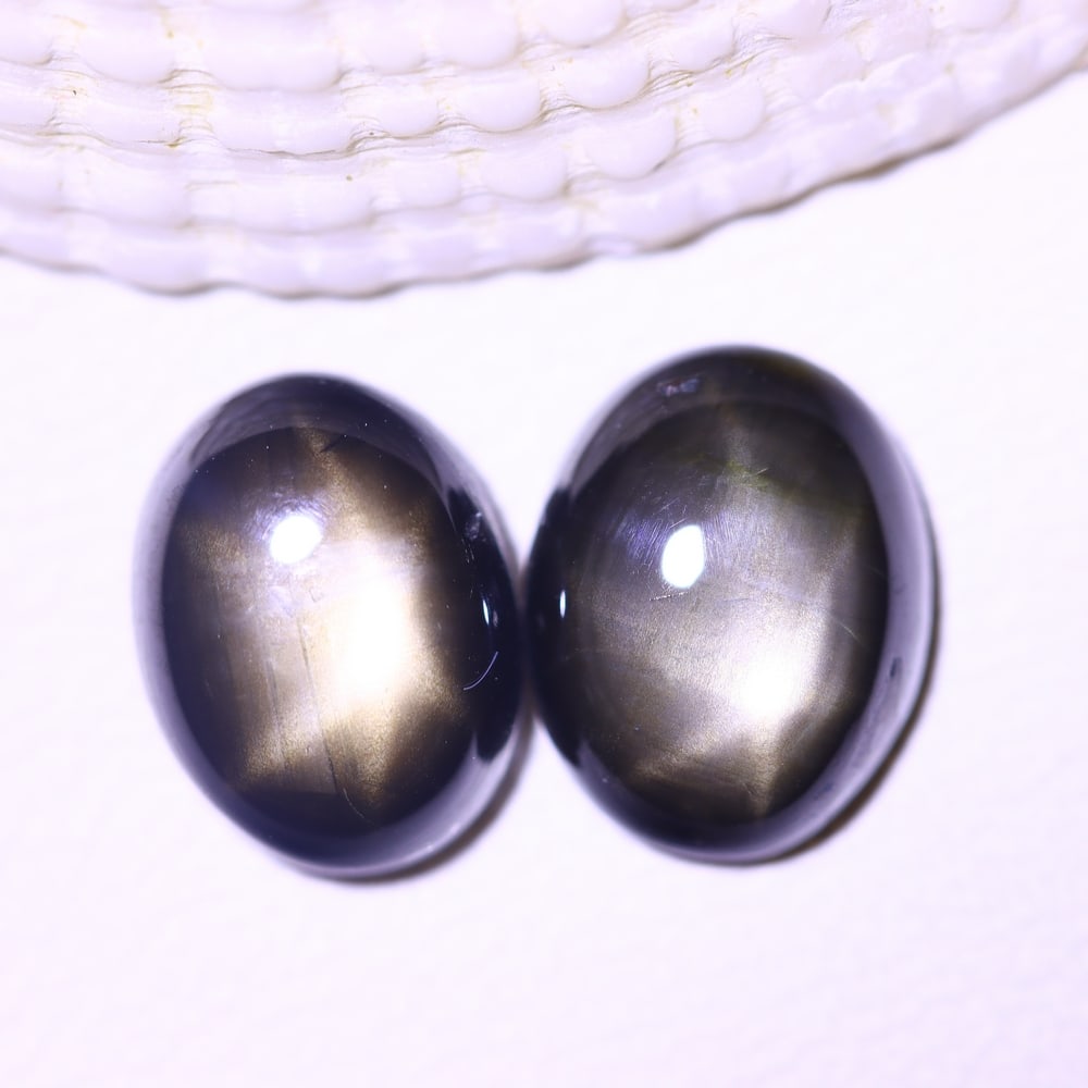 4.61cts 6 Rays Black Star Sapphire Pair , 1218E: Ksmith Heritage Auctioneers Subject: Natural 6 Rays Star Sapphire Origin: Myanmar Carat Weight: 4.61cts Dimension: 8.3x6.3x3.8 mm Treatment: Diffusion Type: Cabochon, Poli