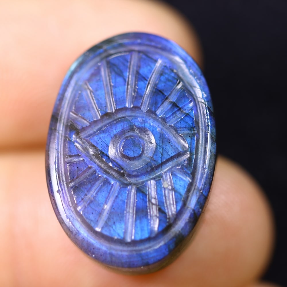 18.52cts Labradorite Evil Eye - Carving , 392E: Ksmith Heritage Auctioneers Subject: Natural Labradorite Origin: India Carat Weight: 18.52cts Dimension: 21.5x15.2x5.8 mm Treatment: Unheated Type: Carving