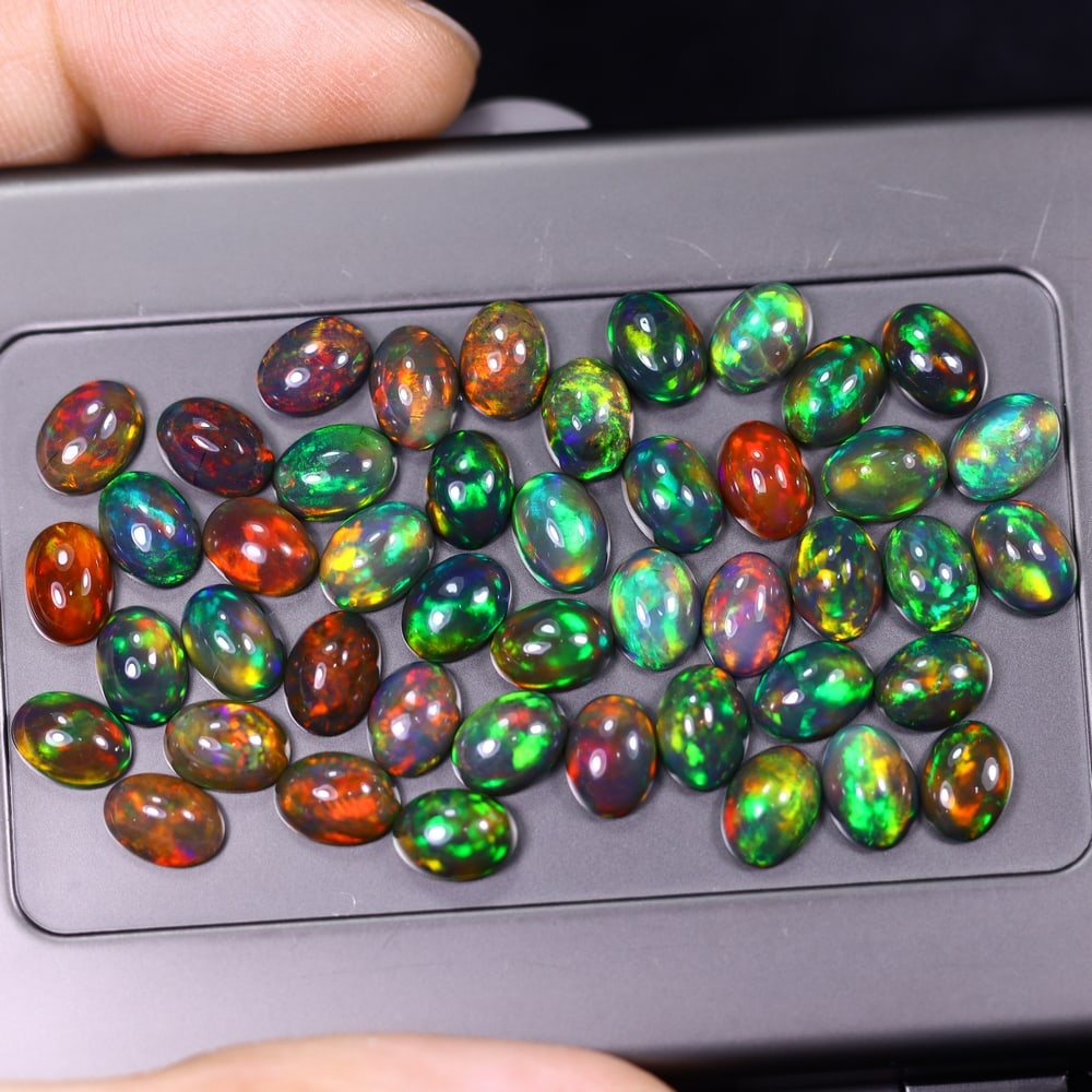 *24.80Ct 7x5mm Smoked Welo Opal Lot - Ethiopian Opal, 371C: Ksmith Heritage Auctioneers Subject: Natural Ethiopian Welo Opal Origin: Ethiopia Carat Weight: 24.80Ct Dimension: 7x5x2.2 mm Treatment: Smoked Type: Cabochon, Polished