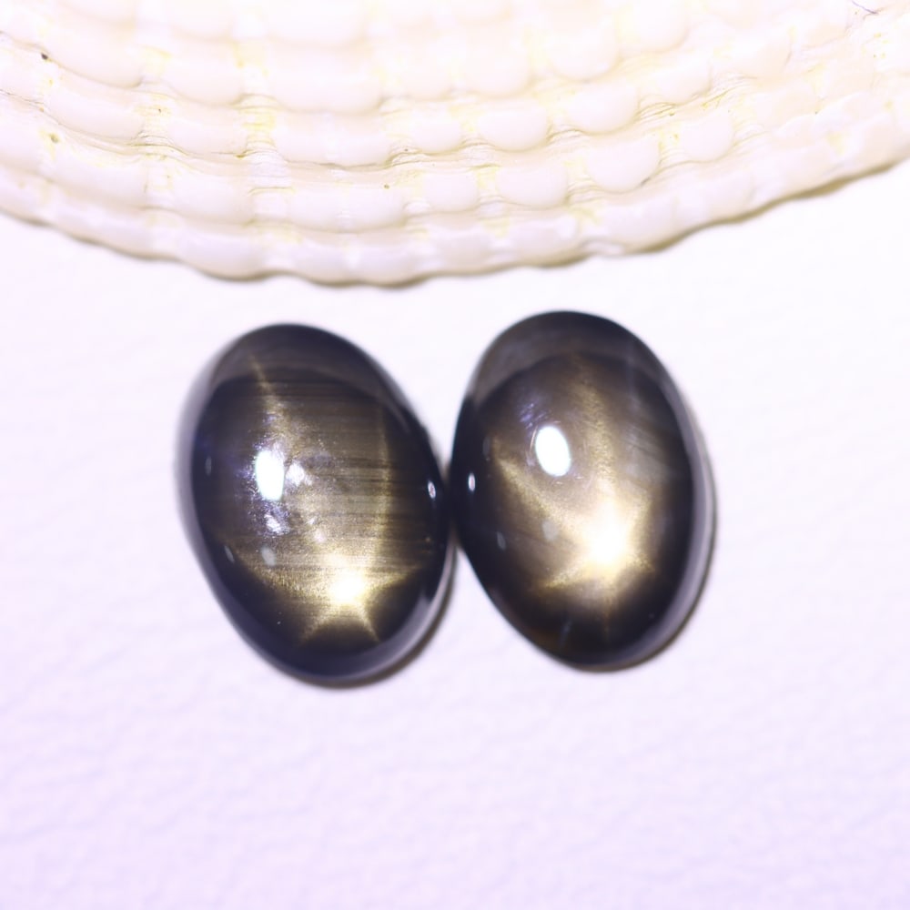 2.05cts 6 Rays Black Star Sapphire Pair , 618E: Ksmith Heritage Auctioneers Subject: Natural 6 Rays Star Sapphire Origin: Myanmar Carat Weight: 2.05cts Dimension: 7.1x5.2x2.5 mm Treatment: Diffusion Type: Cabochon, Poli