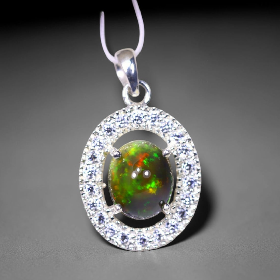 Silver Pendant with Ethiopian Black Opal 3.5grams - 925 Sterling Silver , 103E: Ksmith Heritage Auctioneers Subject: Opal & Simulated Diamond Silver Pendant Carat Weight: 3.5 grams (approx.) Dimension: Opal 10x7mm, Pendant 22x15mm