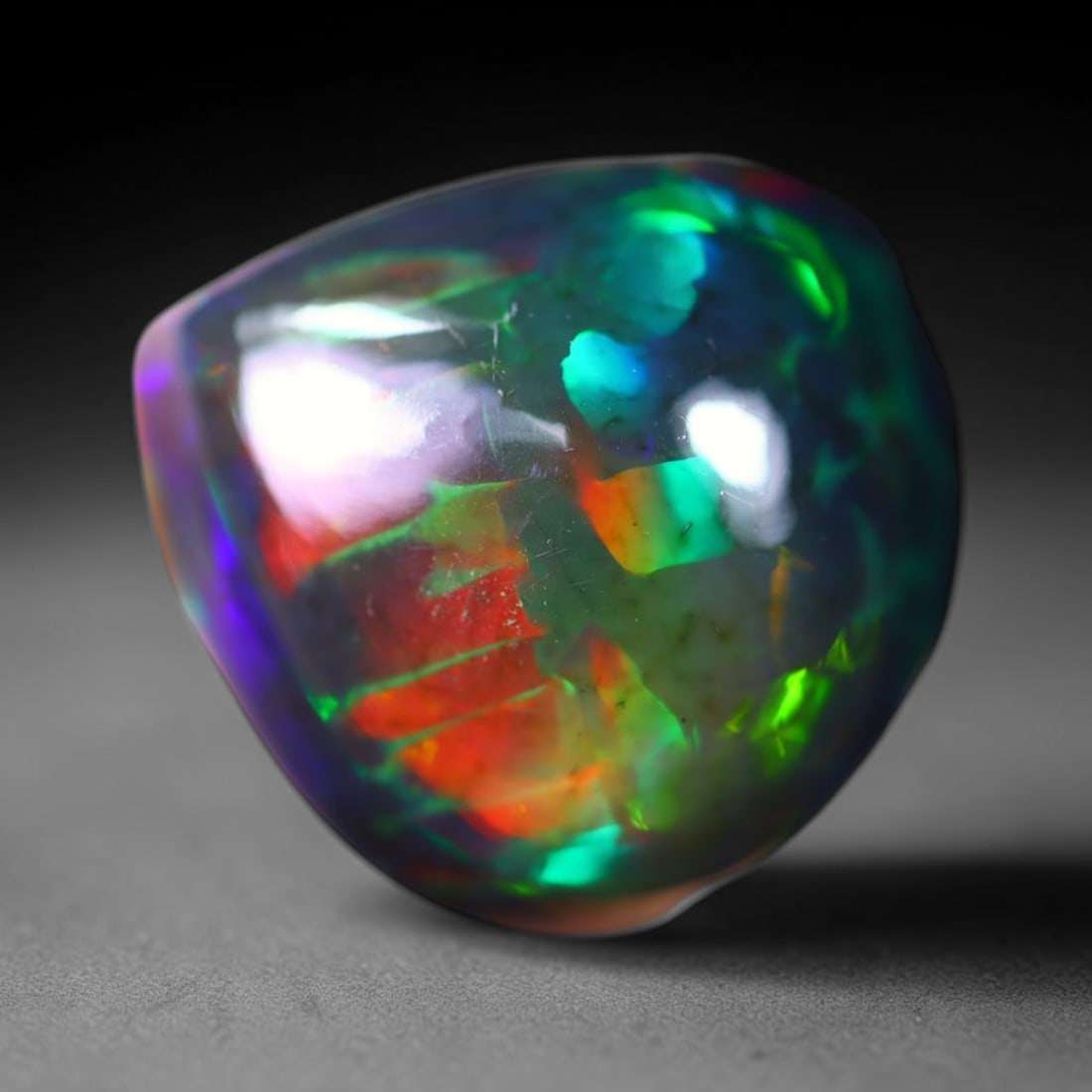 *8.66Ct Welo Black Opal Polished - Ethiopian Opal - Pear Cabochon , 46E: Ksmith Heritage Auctioneers Subject: Natural Ethiopian Welo Black Opal Origin: Ethiopia Carat Weight: 8.66Ct Dimension: 15.4 x 14.6 x 9 mm Treatment: Smoked Shape: Pear