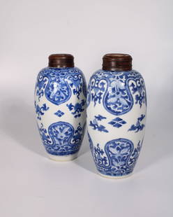 Sotheby's Pair of Kangxi Period Ovoid Vases with Wooden Covers: Measures 10 inches tall and 5 inches wide.