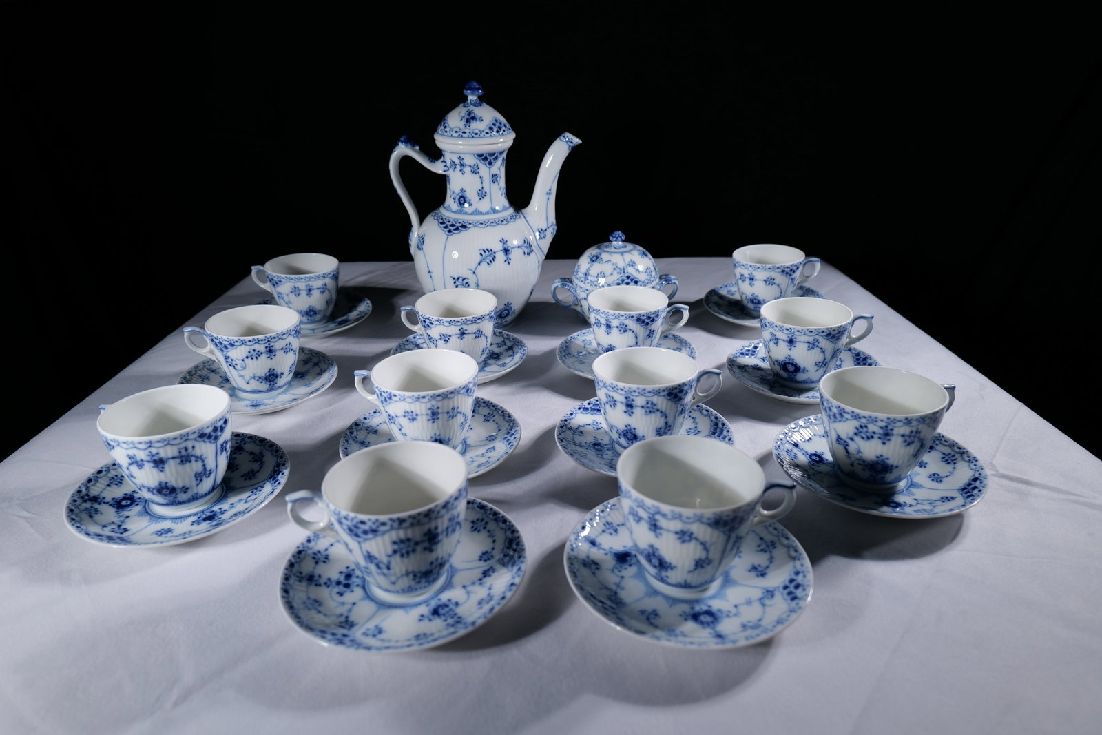 A Group of Royal Copenhagen Porcelain Blue and White Floral Coffee Service: Comprising a tall coffee pot and cover, 9.1/2 in. (24 cm.) high, 7 in. (18 cm.) wide, a sugar bowl and cover, 4.1/8 in. (10.3 cm.) high, 5 in. (12.5 cm.) wide, twelve coffee cups and saucers: cups: 2.