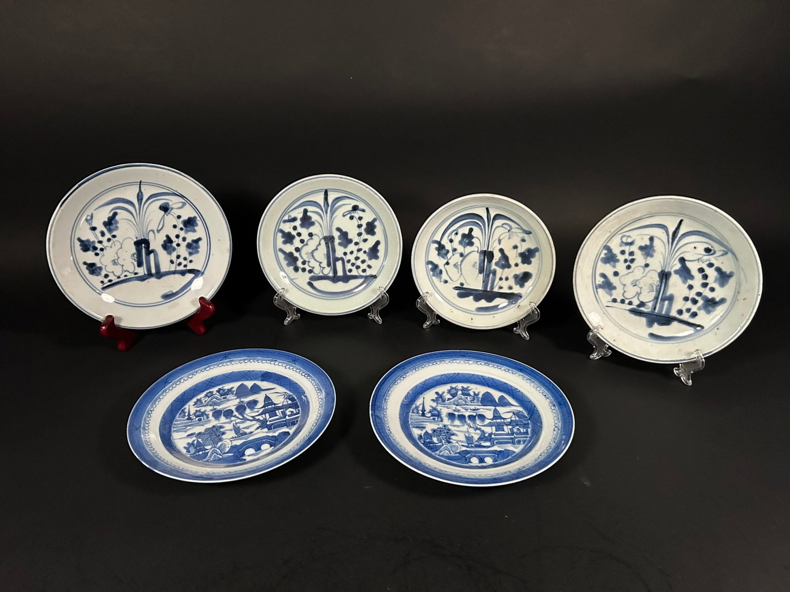 A Group of Six Chinese Export Blue and White Dishes, Qing Dynasty: A pair of blue and white 'landscape' dishes: 7.1/2 in. (19 cm.) diam.; a group of four blue and white 'orchid' dishes, with the smallest measures 6.1/2 in. (16.4 cm.) diam. and the largest measures 7.