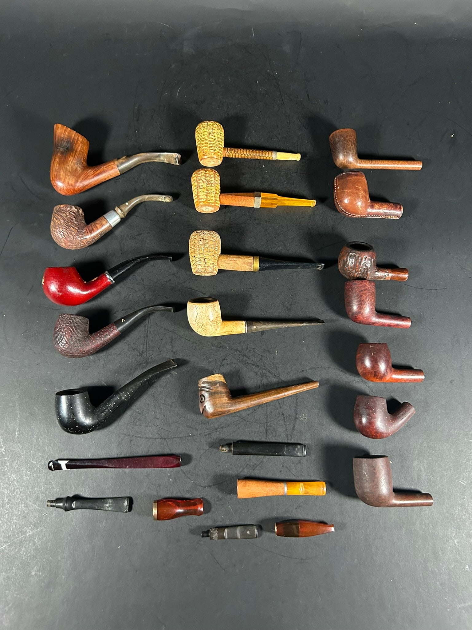 A Group of Ten Smoking Pipes and Fourteen Smoking Pipe Parts: Comprising ten smoking pipes with filters made by Savinelli Autograph, Dr. Grabow Omega, Nirvana, etc., with the largest one measures 6.1/8 in. (15.5 cm.) long; seven smoking pipes without filters, ma
