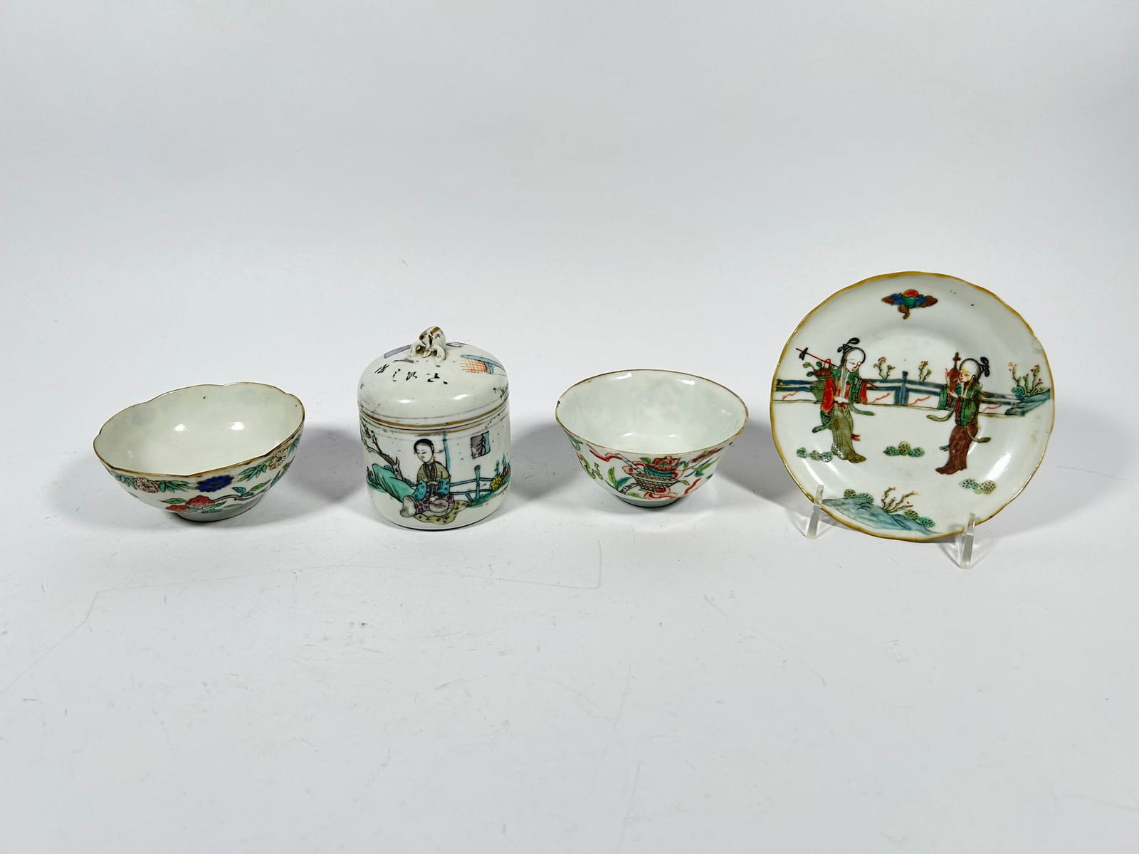 A Group of Four Chinese Famille Rose Porcelain Wares: Comprising a small famille verte dish, with a Tongzhi six-character mark to the bottom, 4.8 in. diam.; a small famille verte jar and cover, with a wine cup inside, signed by Cheng Heshun and with his