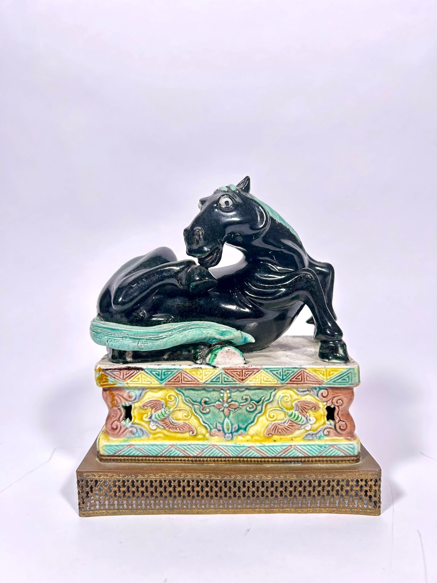 A Chinese Famille Verte Figure of a Horse on a Copper Base, Qing Dynasty: 7.1/4 in. (18.4 cm.) high, 6.1/4 in. (15.9 cm.) wide overall.