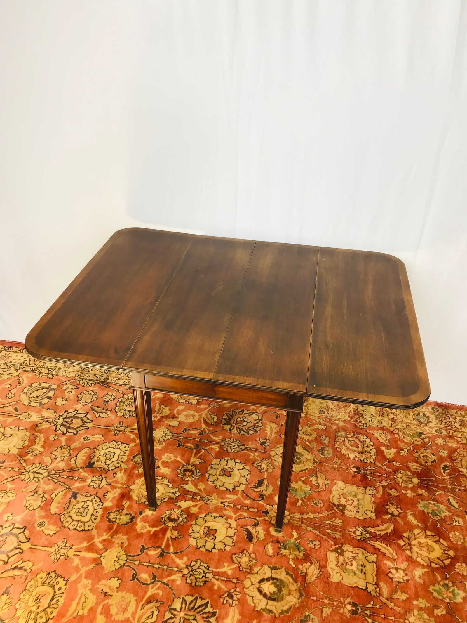 A Brandt Furniture Co. Mahogany Drop Leaf Table: With a certificate issued by the Mahogany Association. INC. 29 in. high, 49.1/2 in. wide, 36 in. deep (extended position).