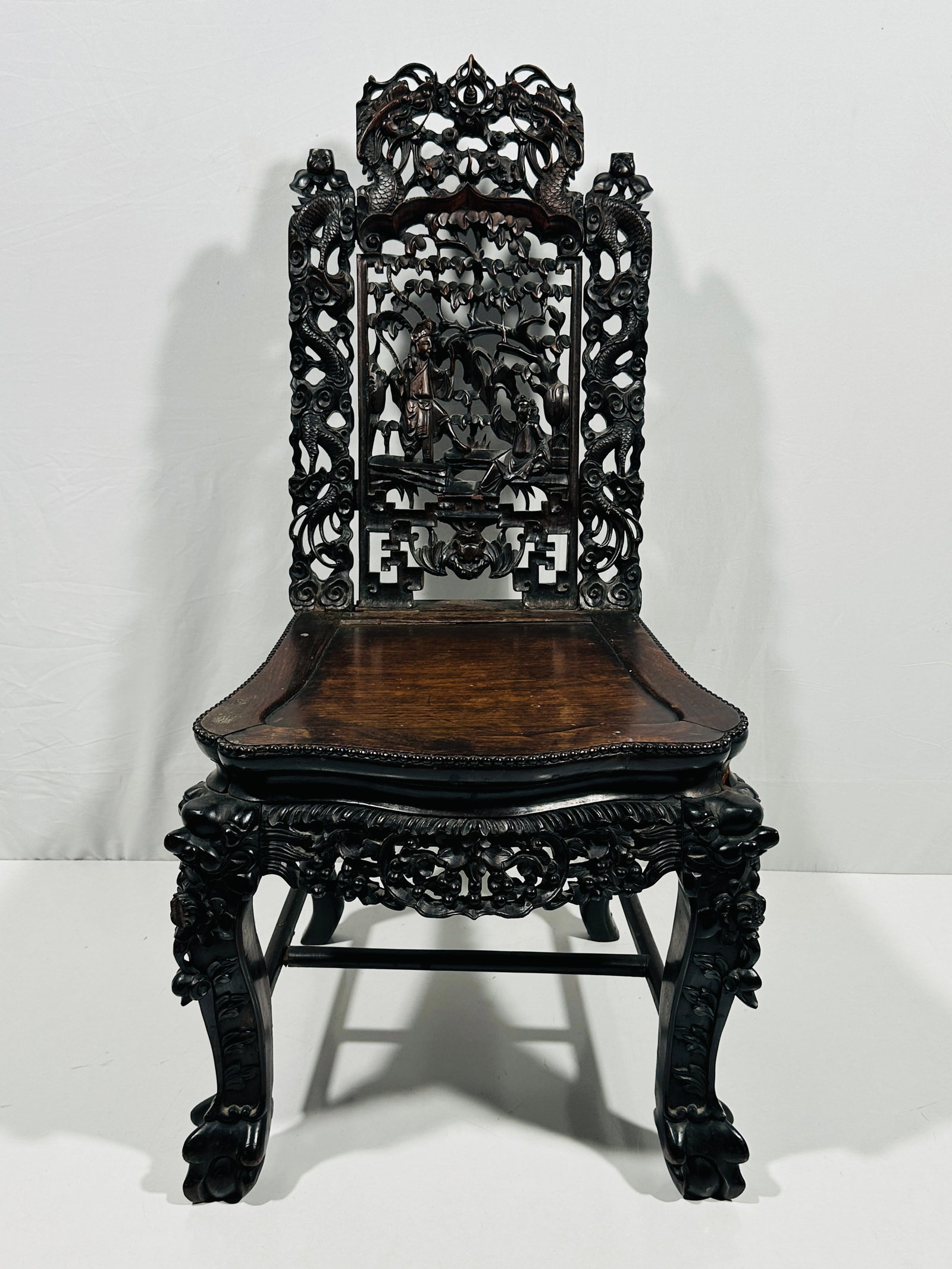 A Chinese Rosewood Carved Chair, 19th Century: 39.25 in. height x 20in. width x 21in. depth, chair features carvings of two dragons and a man and woman