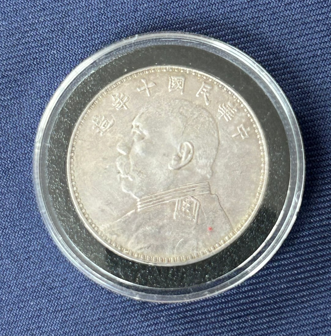 A Chinese One-Yuan Silver Coin, 10th year of Republic of China, 1921: 1.1/2 in. diam. for the coin, with a fitted plastic container.