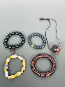 A Group of Four Chinese Shouchuan and a Dzi Bead