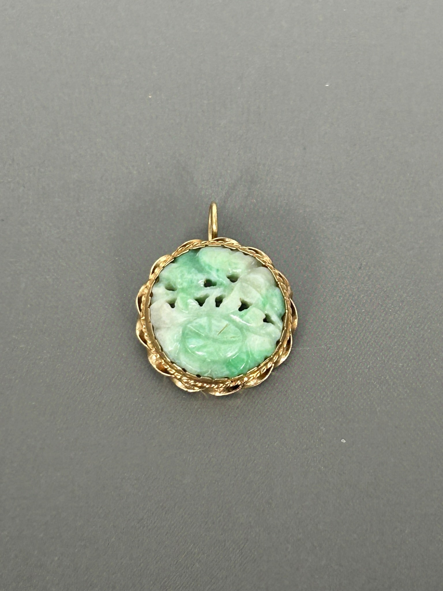 A Jadeite-Inset 14K Yellow Gold Pendant: With a '14k' mark to the rim, 3/4 in. diam.