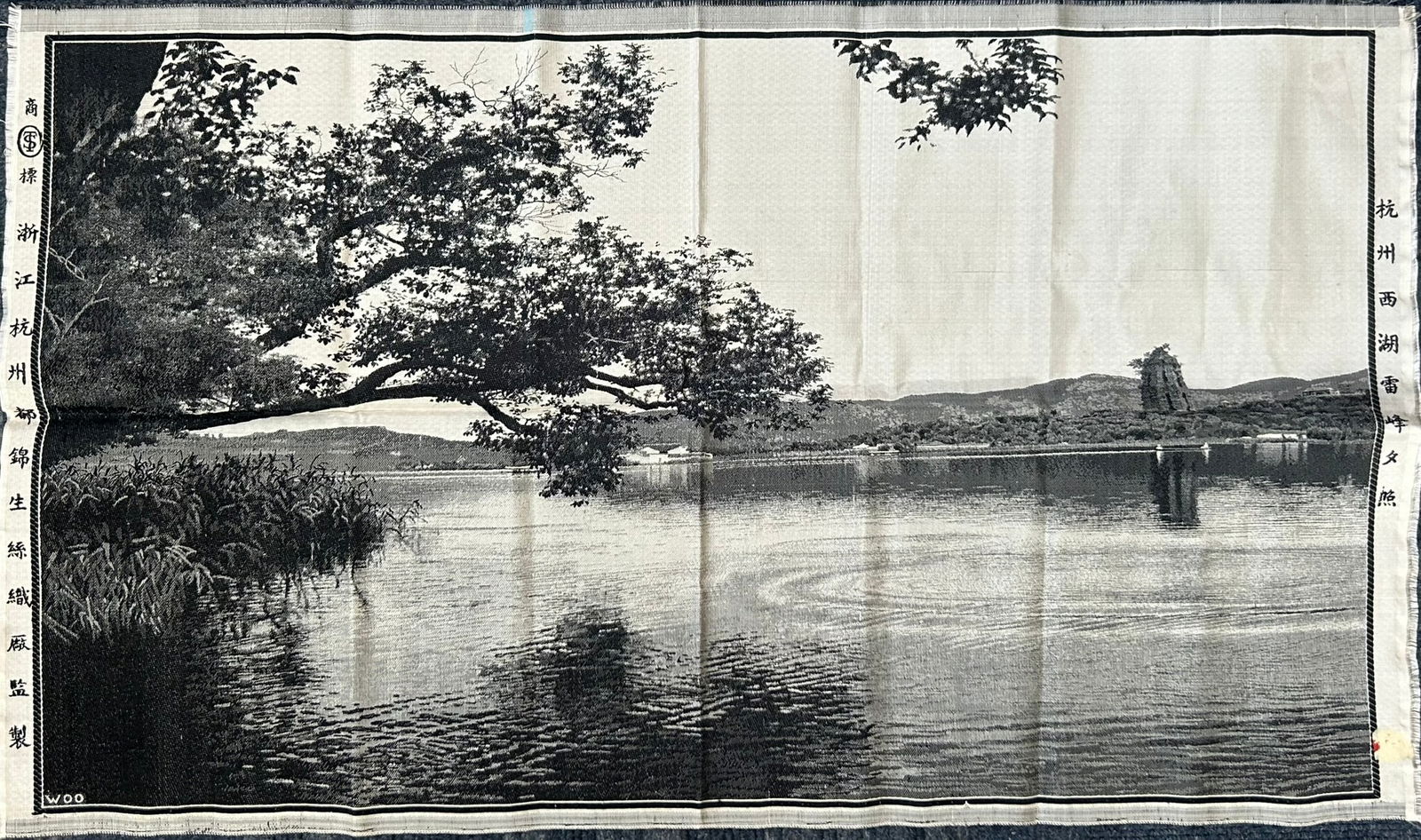 A Chinese Silk Brocade 'Leifeng Pagoda' Panel: With manufacturer's mark 'manufacturing was supervised by the Du Jin Sheng Silk Weaving Factory, Hangzhou, Zhejiang' and a title 'Sunset of the Leifeng Pagoda, West Lake, Hangzhou' 28.1/2 in. x 17 in.
