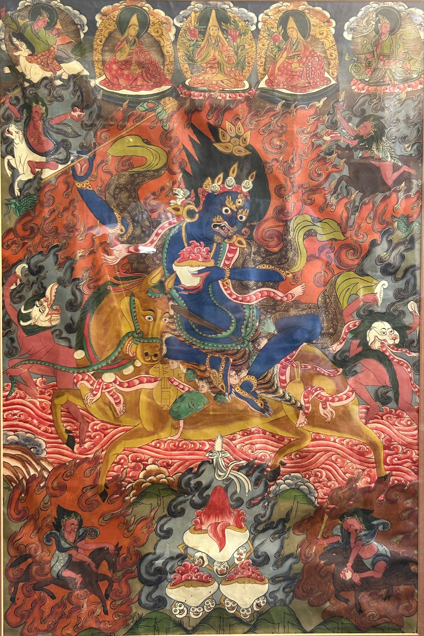 A Tibetan Painting of Palden Lhamo, Thangka: Depicting the dark-skinned deity astride a snorting, rearing horse as it charges across a churning crimson sea. 29 1/2 in. high, 20 3/4 in. wide.