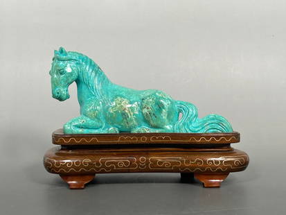A Chinese Carved Turquoise Horse: Mounted on a wood stand, 4.5/8 in. high, 7 in. wide overall.